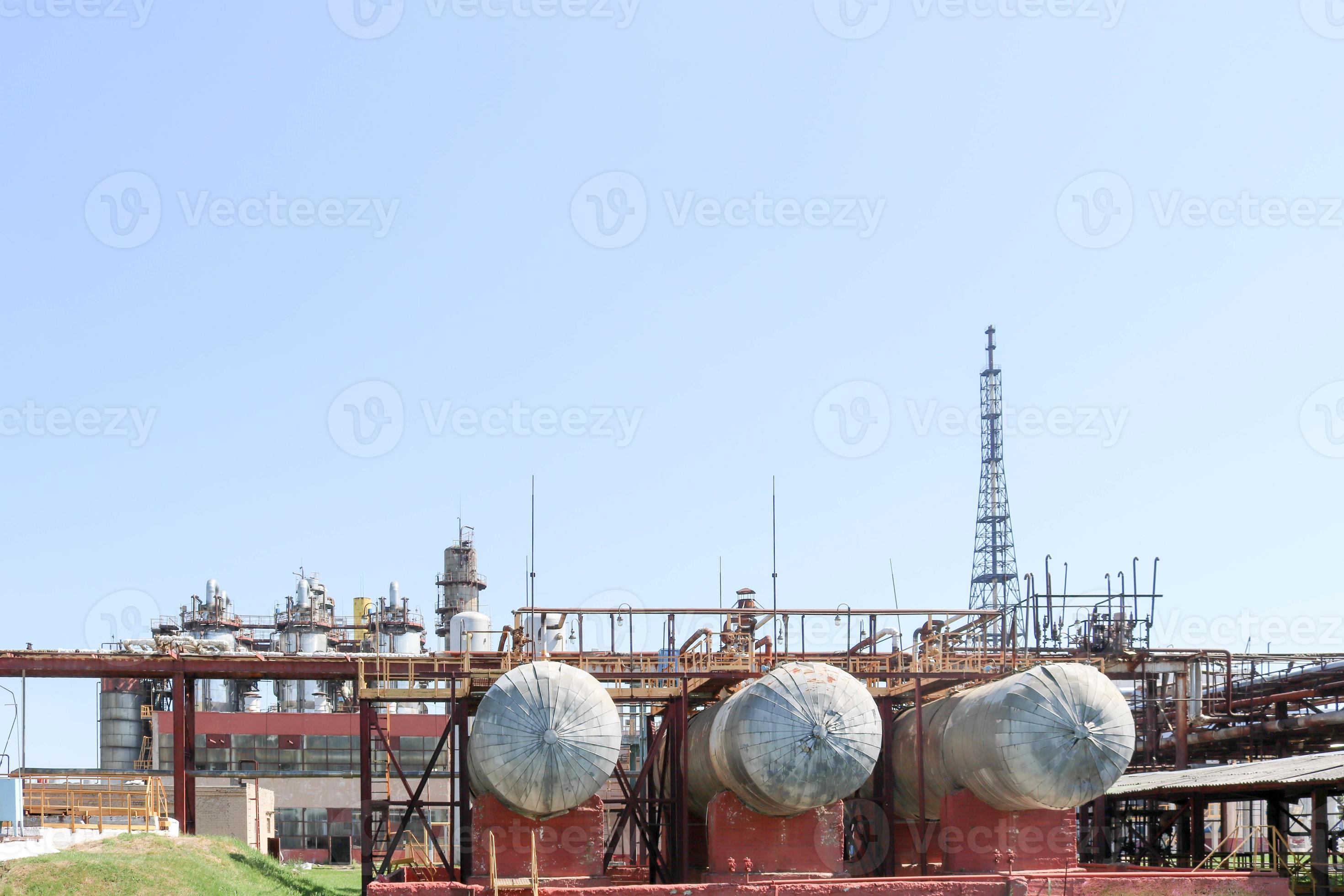A large metallic iron pipeline trestle with pipes and wires for electricity in a petrochemical