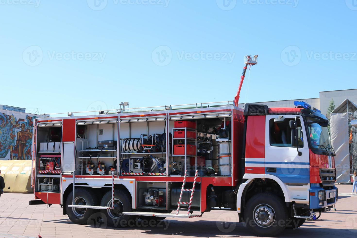 coche de bomberos especial grande rojo con azul, motor para rescate de personas con los lados abiertos y equipo de extinción, bomba contra incendios, agente espumante, herramienta, mangas de agua, mangueras, balones, equipo. foto