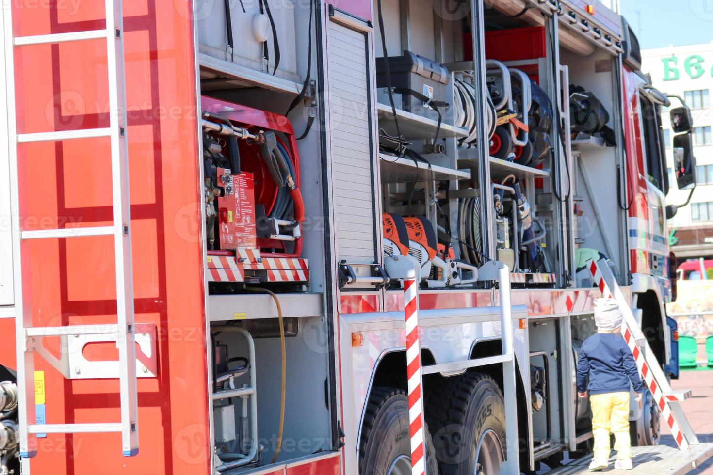 coche de bomberos grande especial rojo con azul, motor para rescatar personas con los lados abiertos y equipo de extinción, bomba contra incendios, agente de soplado, herramienta, manguitos de agua, mangueras, balones, equipo foto