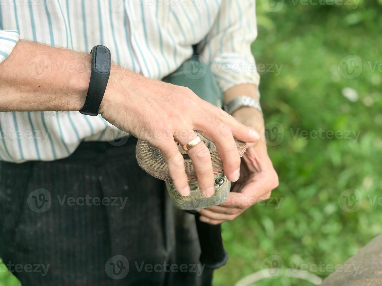 A man holds in his hand a disk of a circle used for a grinding machine for grinding and polishing surfaces from various material wood, metal, plastic, stone photo