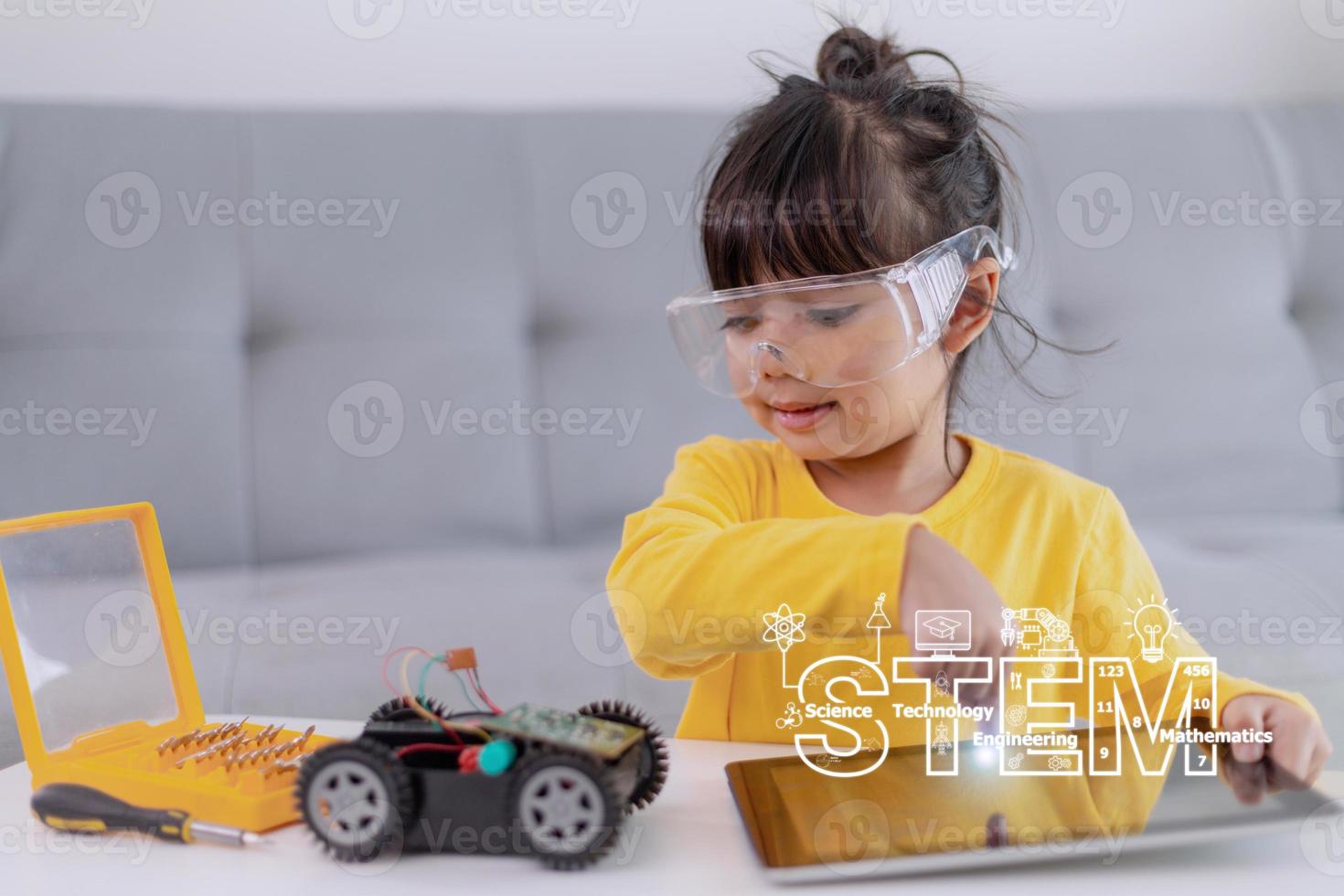 Little girls having fun in a workshop coding robot car photo