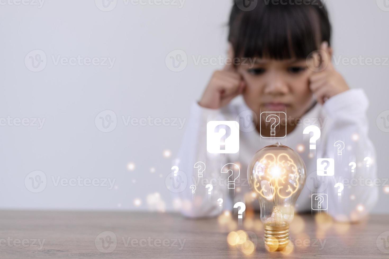 niña pensante con bombilla y signos de interrogación. lluvia de ideas y concepto de idea foto