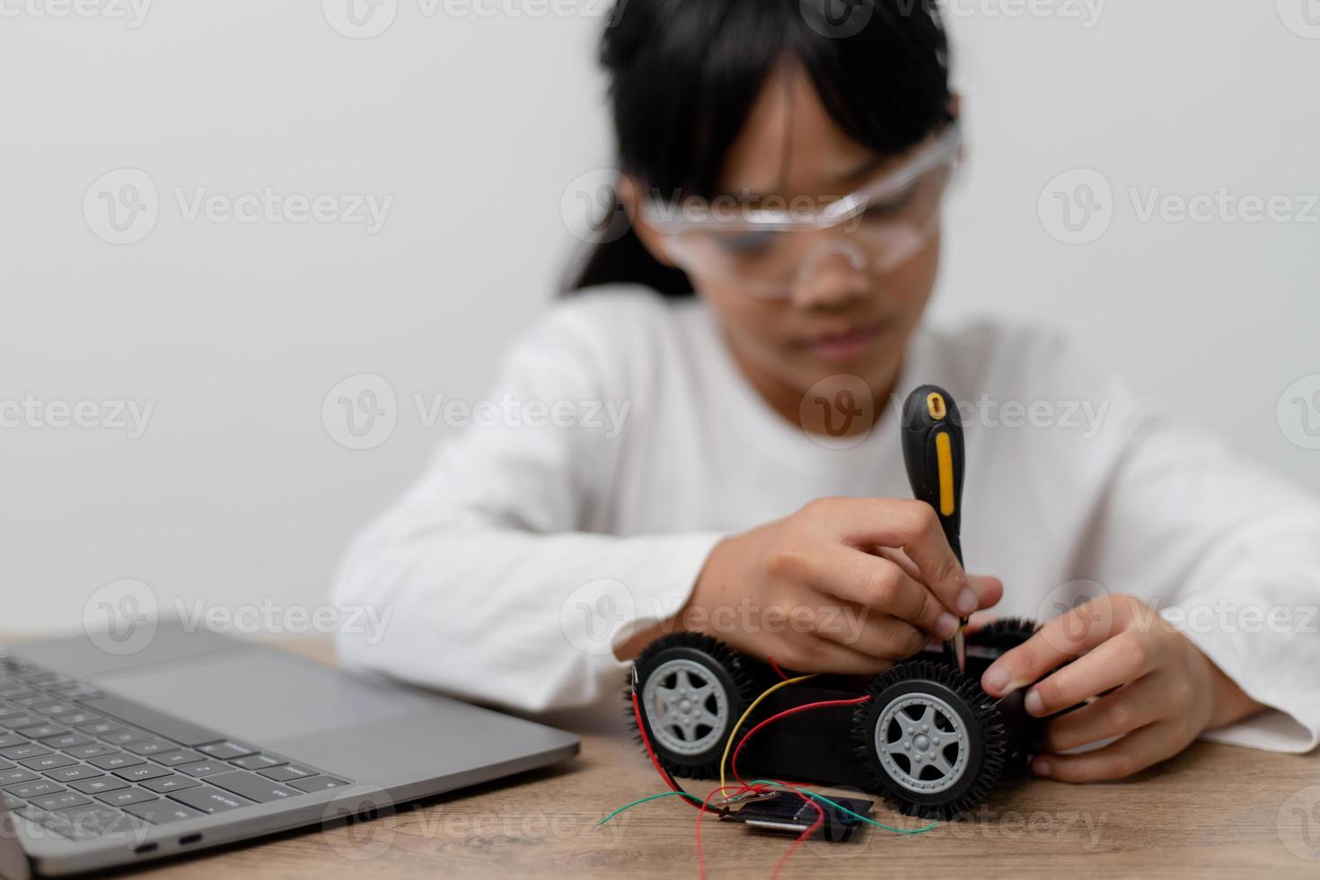 Asia students learn at home in coding robot cars and electronic board cables in STEM, STEAM, mathematics engineering science technology computer code in robotics for kids concept. photo