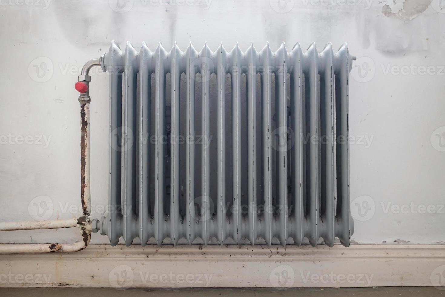 Old radiator, gray, in the room. Close-up. photo