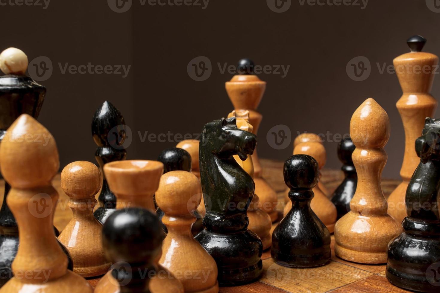Old wooden chess standing group on the board, as if plotting something. photo
