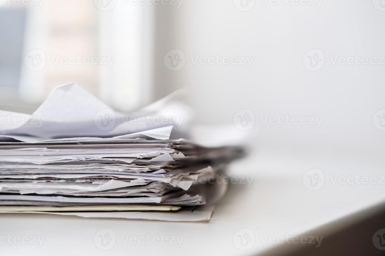 A stack of paper for writing and notebooks on a white windowsill in natural light from the window. photo