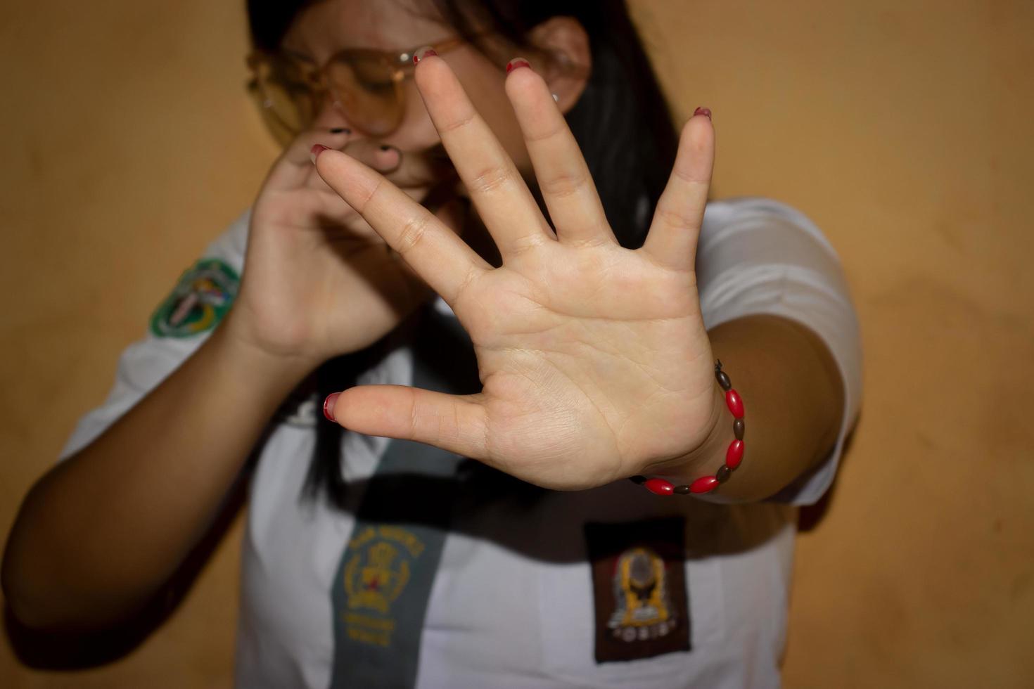 las manos de una mujer en un uniforme de escuela secundaria concepto de detener el acoso escolar. foto