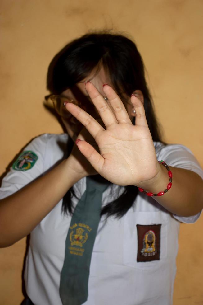 the hands of a woman in a high school uniform  concept of a stop bullying at school. photo