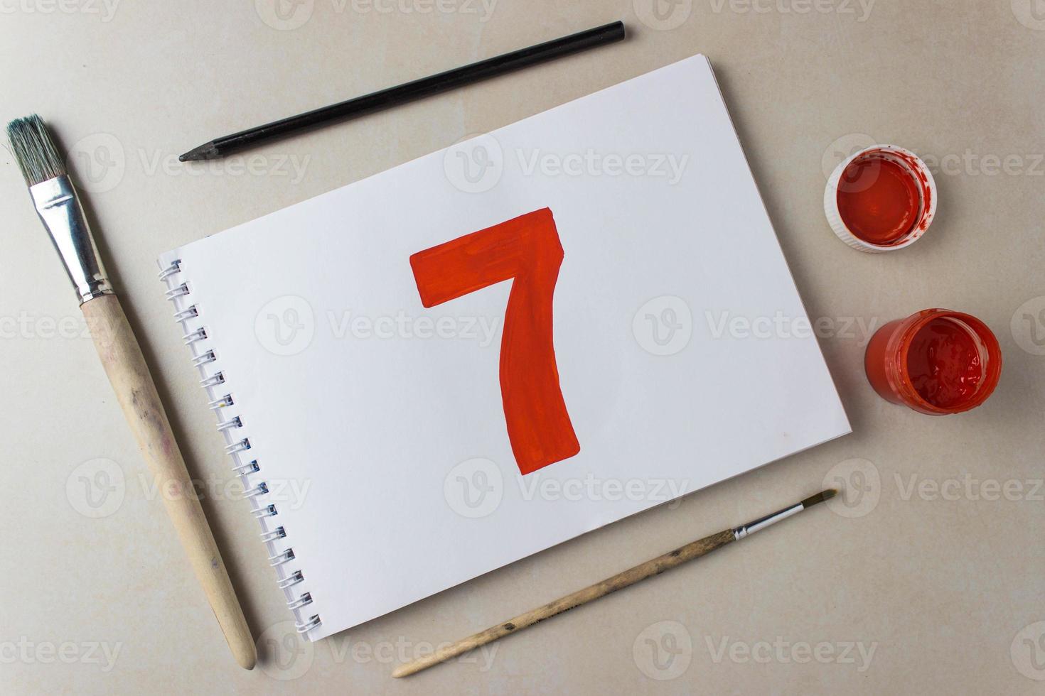 Red number seven drawing on a white album sheet. To indicate the place, price, etc. photo