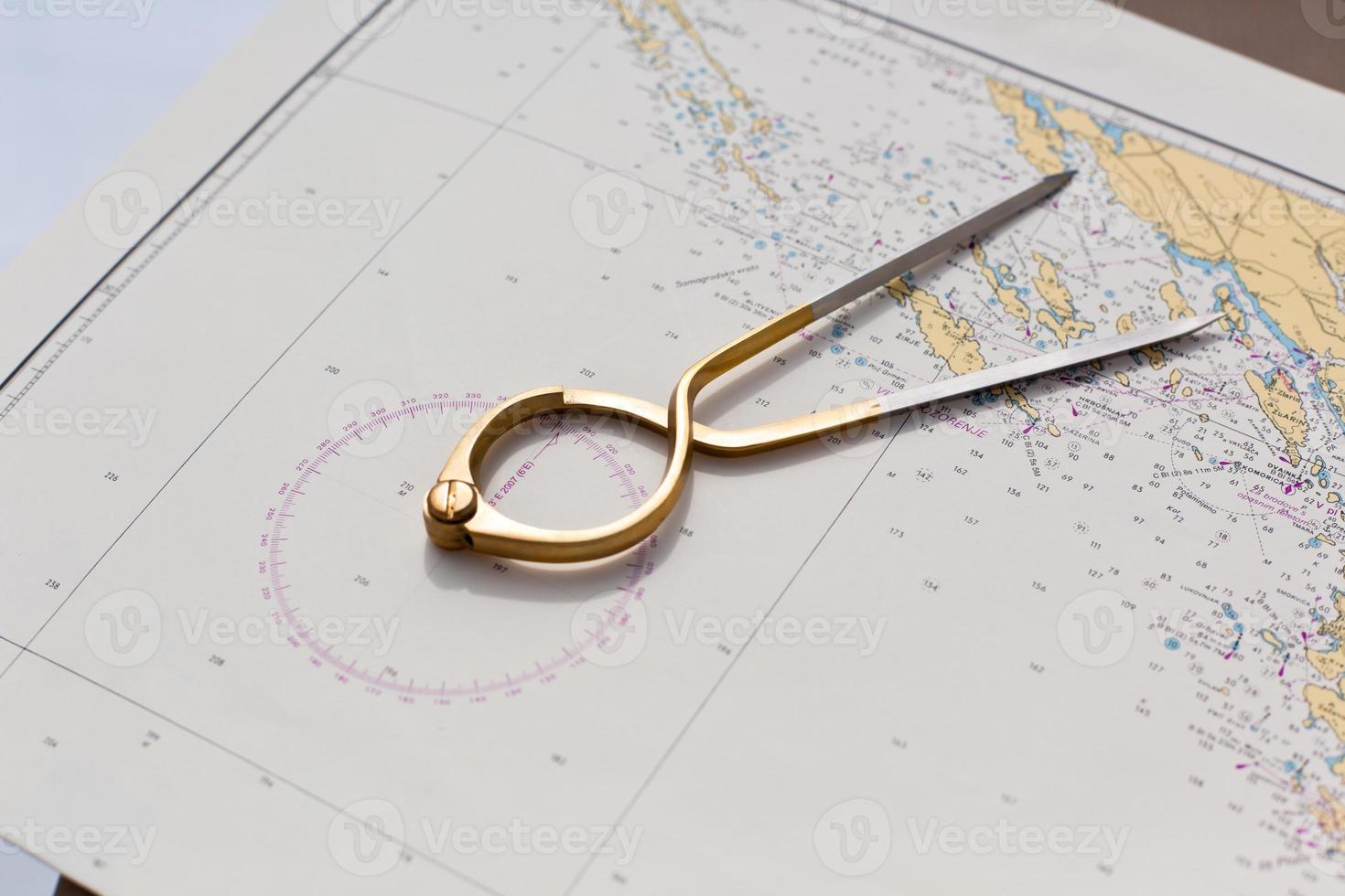 Pair of compasses for navigation on a sea map photo