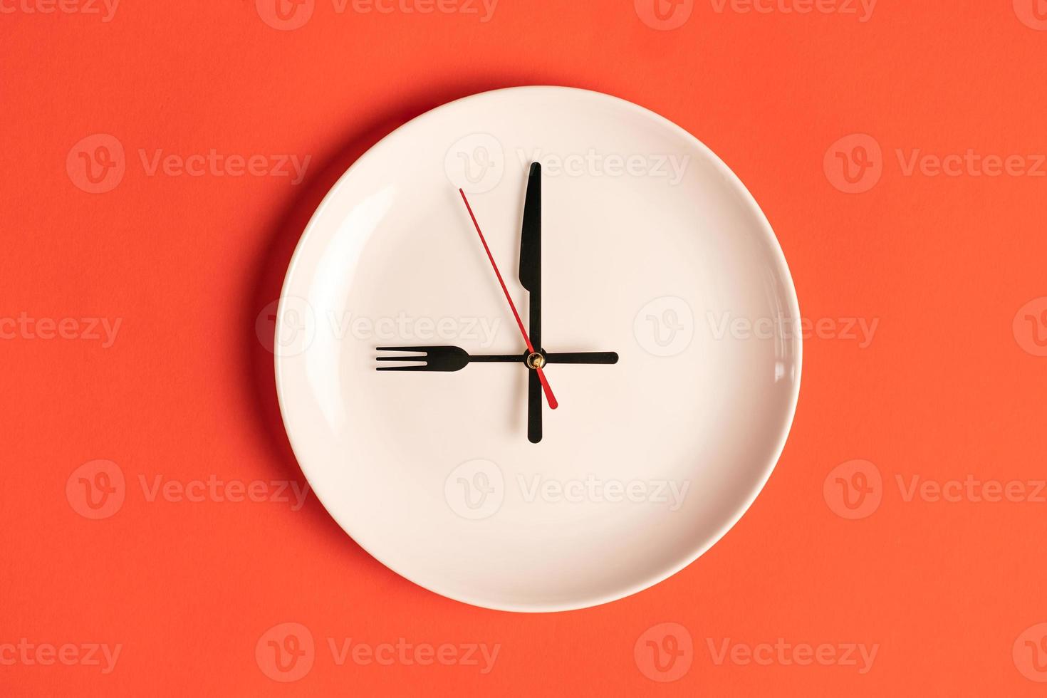 plate with hour hands in the form of a fork and knife, time to eat. photo