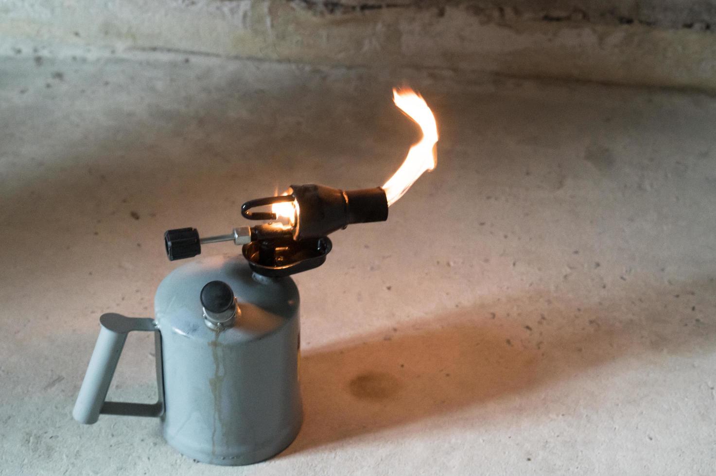 Gasoline blowtorch with a burning fire, the use of a blowtorch in construction. photo