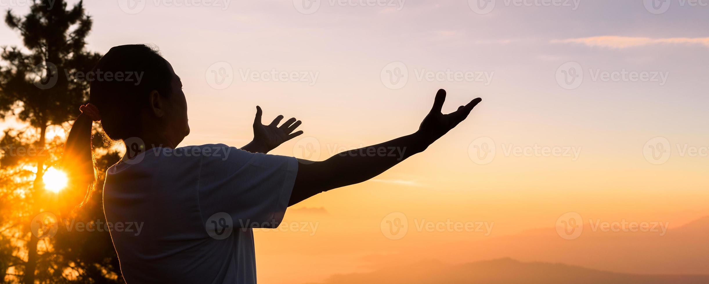 la fe del concepto cristiano la oración espiritual entrega el sol con un hermoso amanecer o atardecer de fondo borroso. cristianos que creen, fe en la oración de la mañana de dios. foto