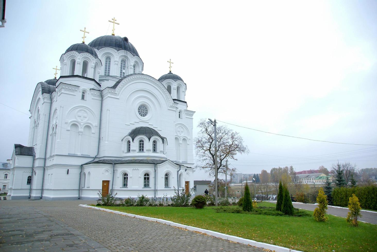 A large white stone church with a golden dome and a bell in eastern Europe is a Christian orthodox for the prayers of God photo