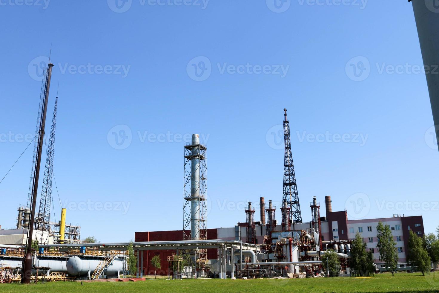 A large concrete technological industrial installation at a chemical petrochemical refinery with capacitive pipes by pumps compressors heat exchangers by pipelines and buildings photo