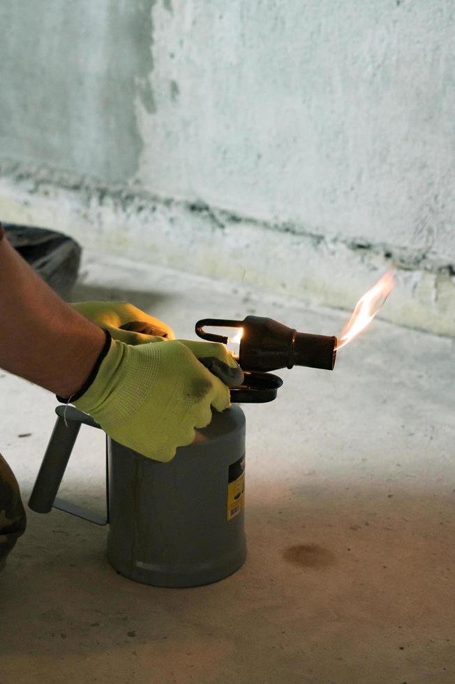 Gasoline blowtorch with a burning fire, the use of a blowtorch in construction. photo