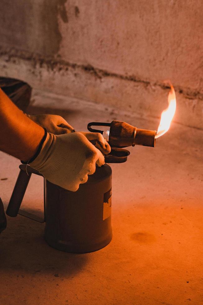 Gasoline blowtorch with a burning fire, the use of a blowtorch in construction. photo