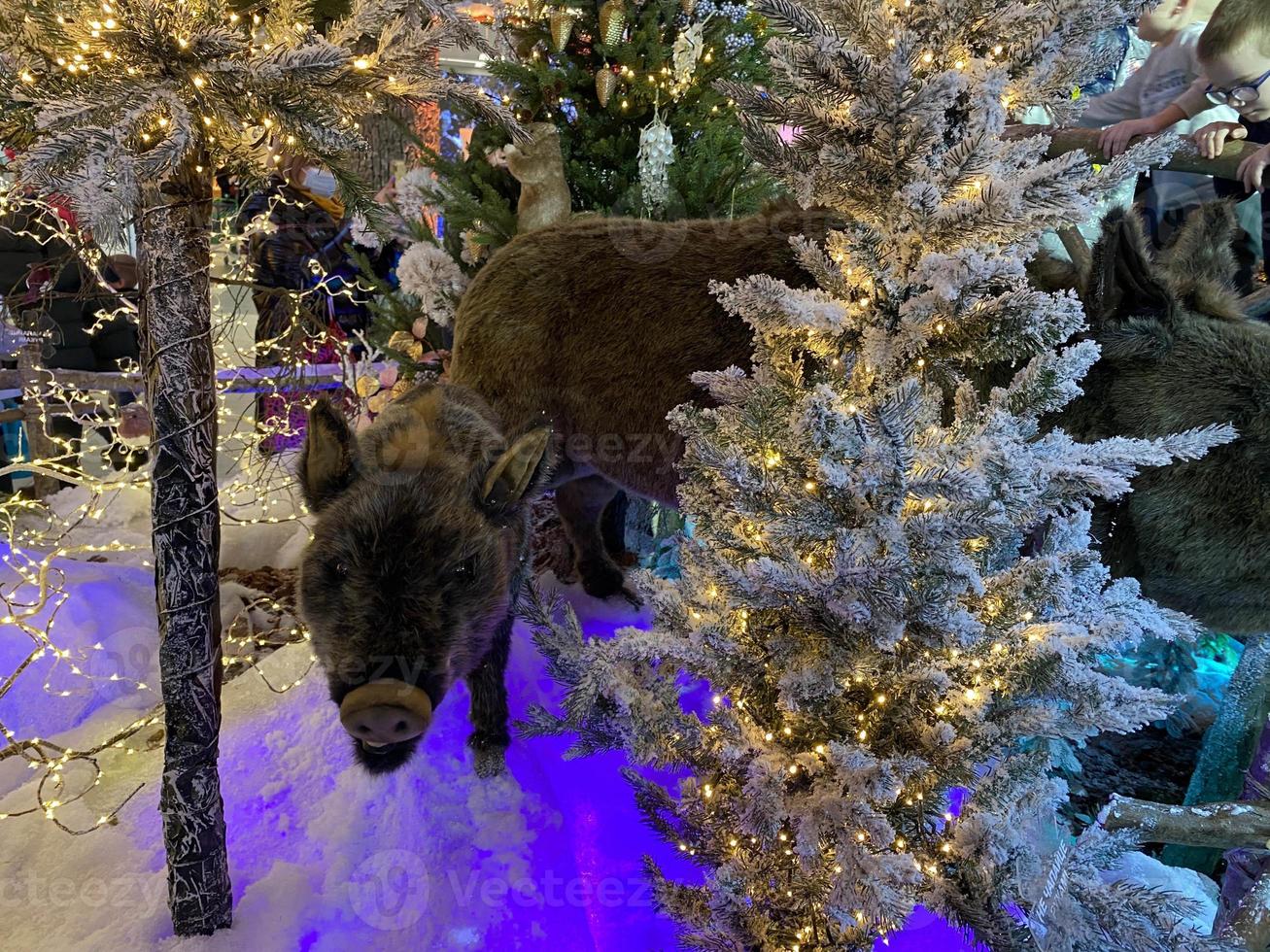 Christmas decoration with toy wild boar, small christmas tree and lights garland. Christmas and Happy New Year concepts. Image for design photo