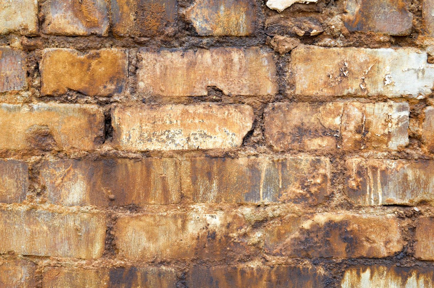 Texture of brick from an old brick wall with seams with dirty streaks of patches wretched ugly old. The background photo