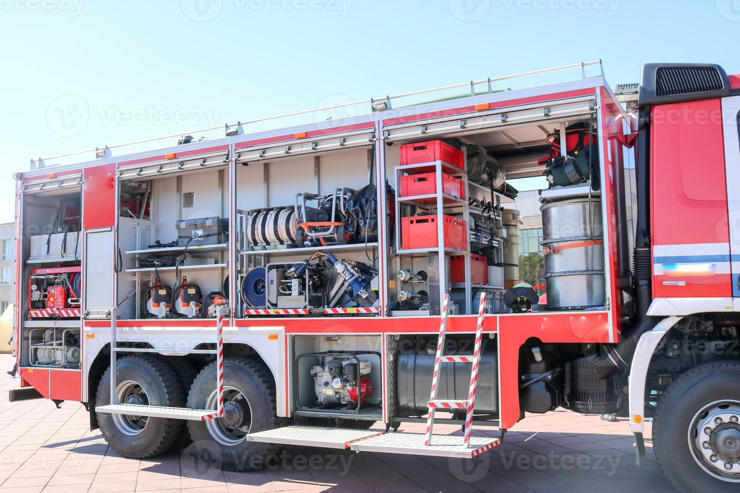 Large special red with blue fire car, engine to rescue people with open sides and extinguishing equipment, fire pump, blowing agent, tool, water sleeves, hoses, baloons, equipmen photo