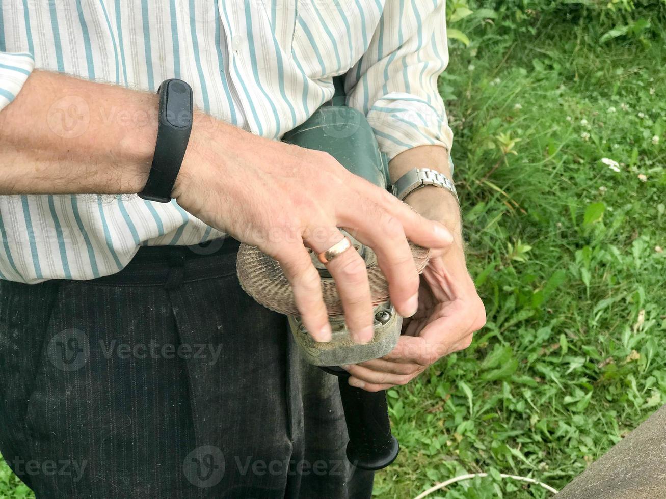 un hombre sostiene en su mano un disco de un círculo usado para una máquina de moler para moler y pulir superficies de varios materiales madera, metal, plástico, piedra foto