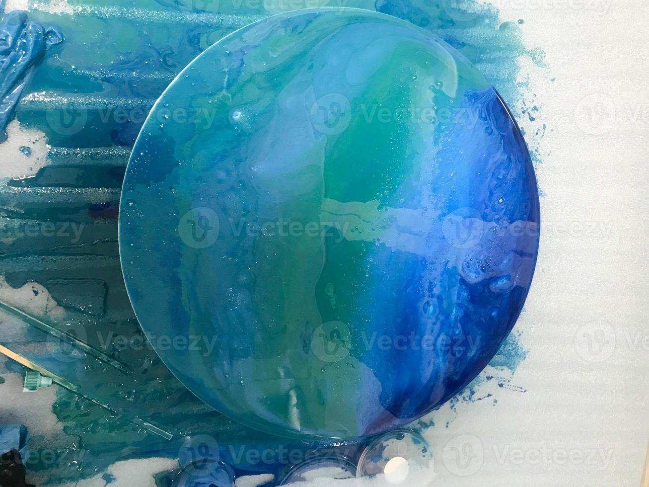 The process of creating a home-made trendy abstract modern pattern painted  with a brush of acrylic blue multi-colored resin on a round wooden boar  14273848 Stock Photo at Vecteezy