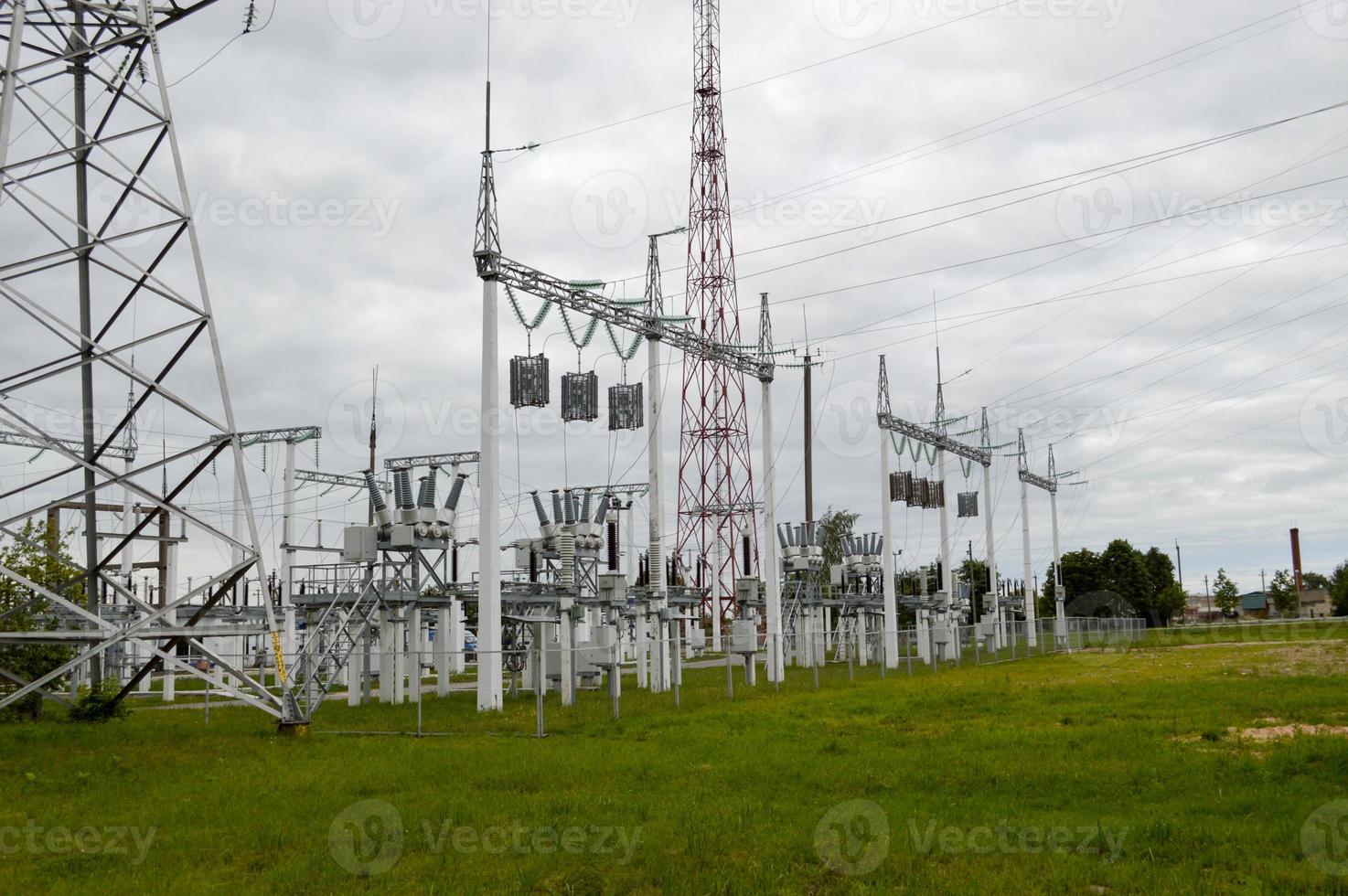 línea de transmisión metálica con los componentes de la red eléctrica, el sistema de equipos de potencia para la transmisión de electricidad, corriente eléctrica con el transformador en la central eléctrica foto