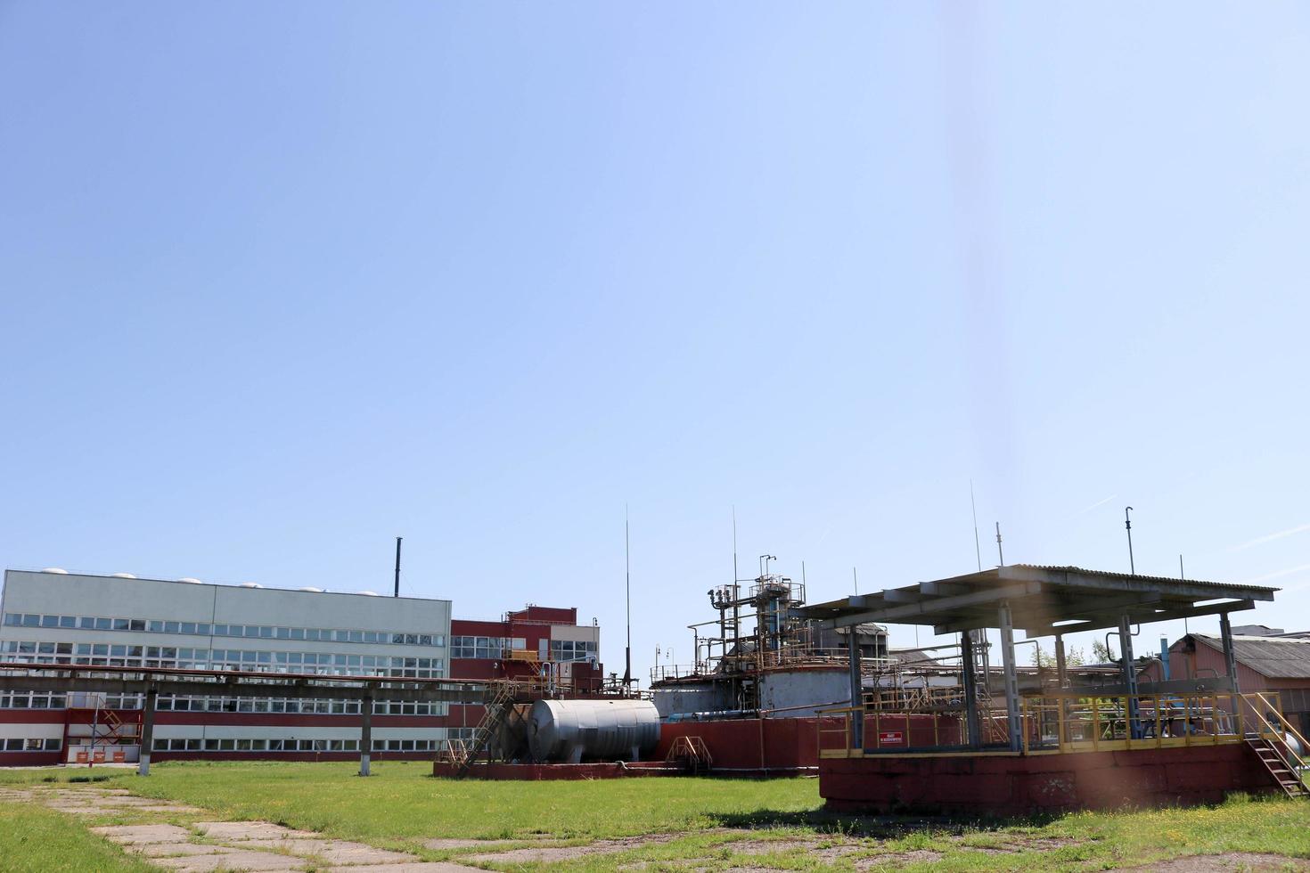 A large concrete technological industrial installation at a chemical petrochemical refinery with capacitive pipes by pumps compressors heat exchangers by pipelines and buildings photo