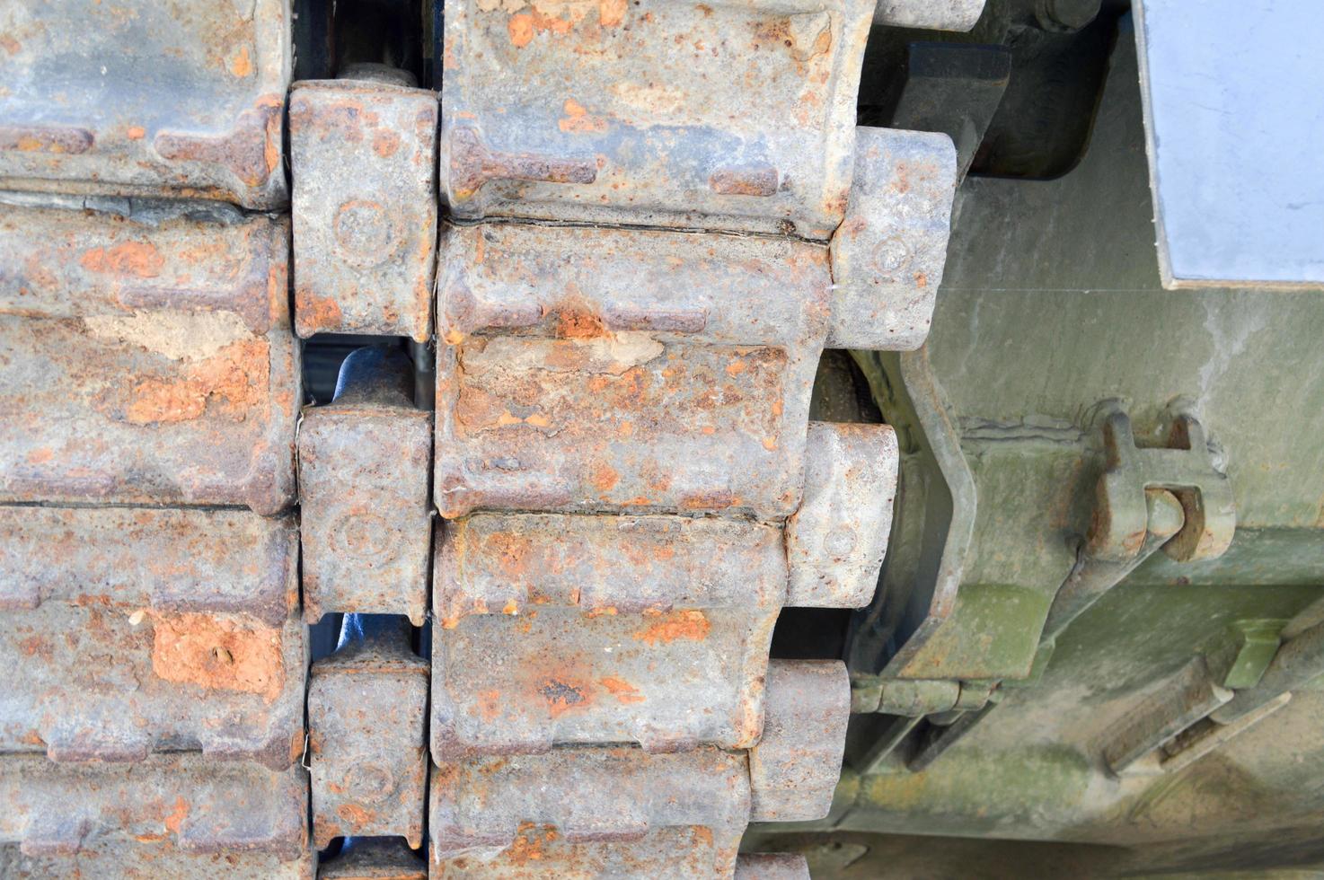 Rusty iron dirty metal heavy track caterpillar of a large green military off-road armored deadly dangerous Russian Syrian battle tank and bottom photo