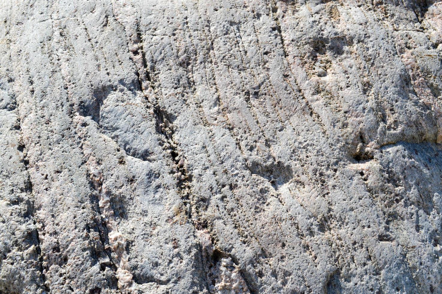 Texture of natural natural carved solid strong rough rough sharp textured mineral gray brown stone cobblestone on the walls of the rock. Stone background photo