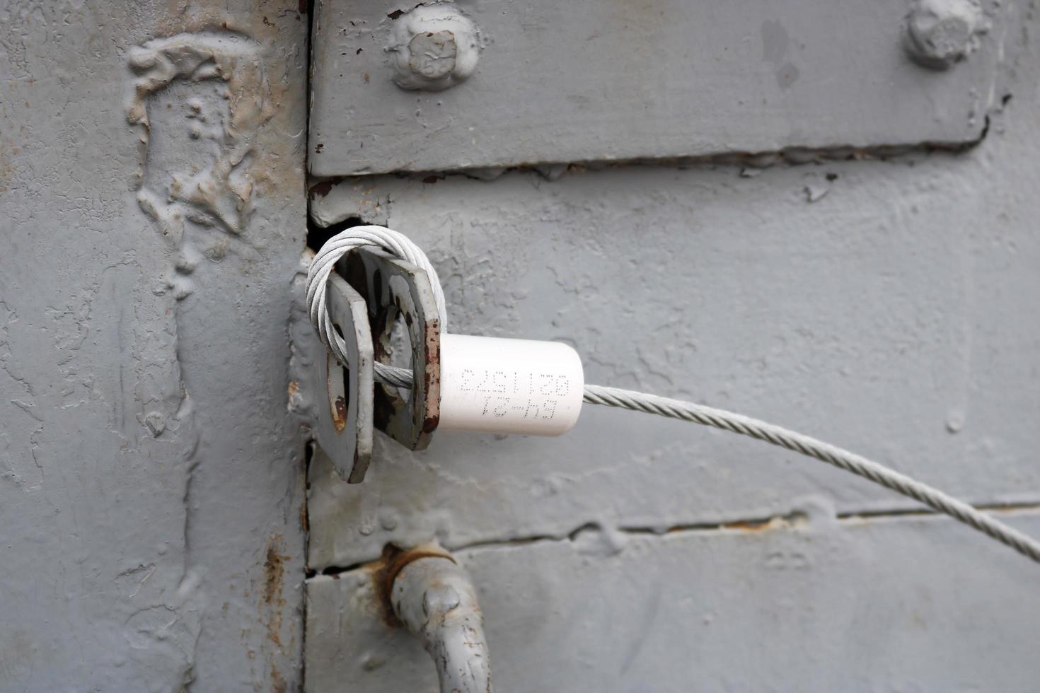 textura de una puerta de metal de hierro azul con una cerradura hecha de cuerda de alambre de metal artesanal improvisada. el fondo foto