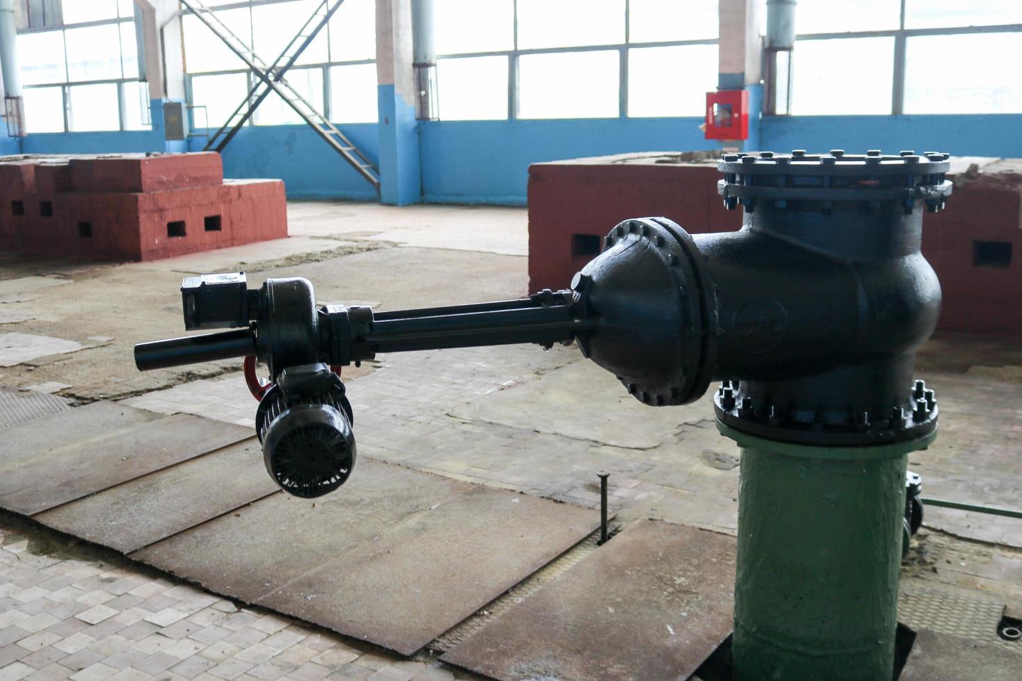 A large black metal iron gate valve with an electric drive at an industrial plant photo