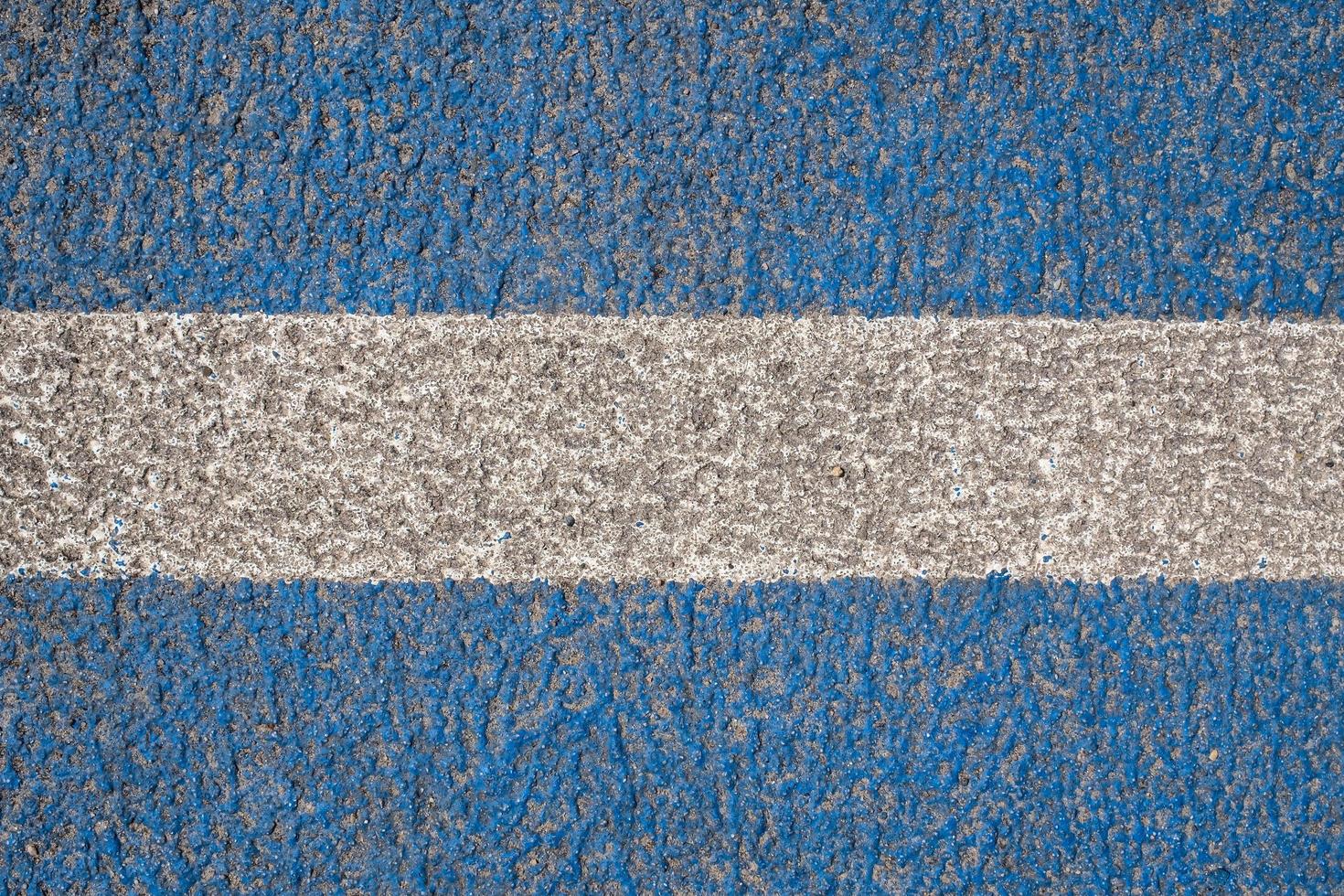 Asphalt is painted blue with a white stripe in the center. Road marking. Textured background. copy space. Top view. photo