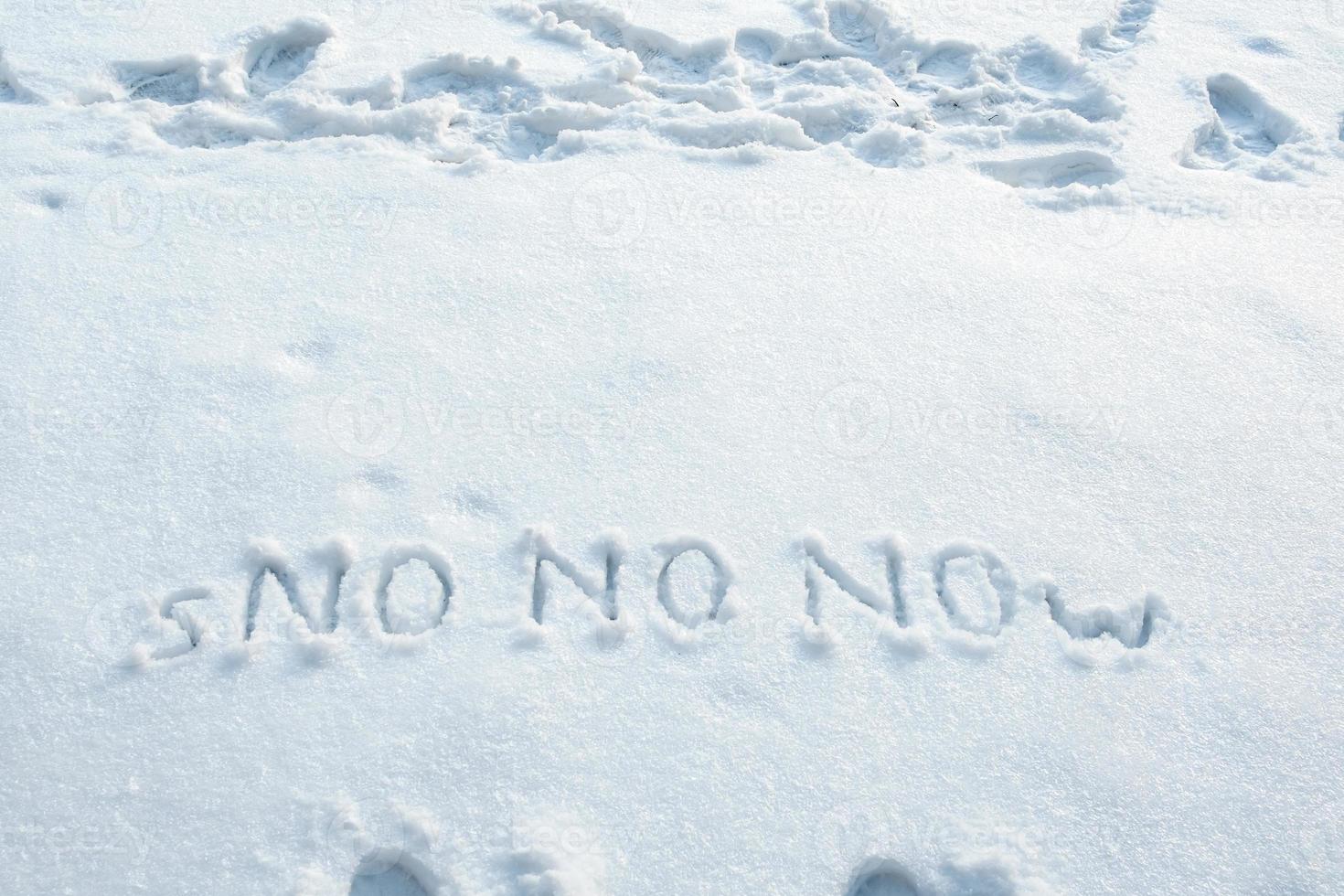 Word of snow and three times in large letters NO written on a snowbank. Spring anticipation concept. Copy space. Creative idea. photo