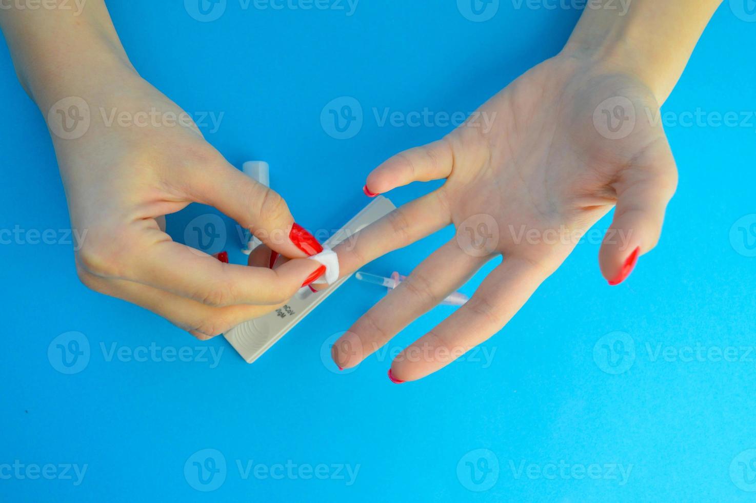 collection of capillary blood from a finger. after analysis, rub the finger with alcohol to stop bleeding. testing for coronavirus. next to a test strip and a lancet with an injection photo