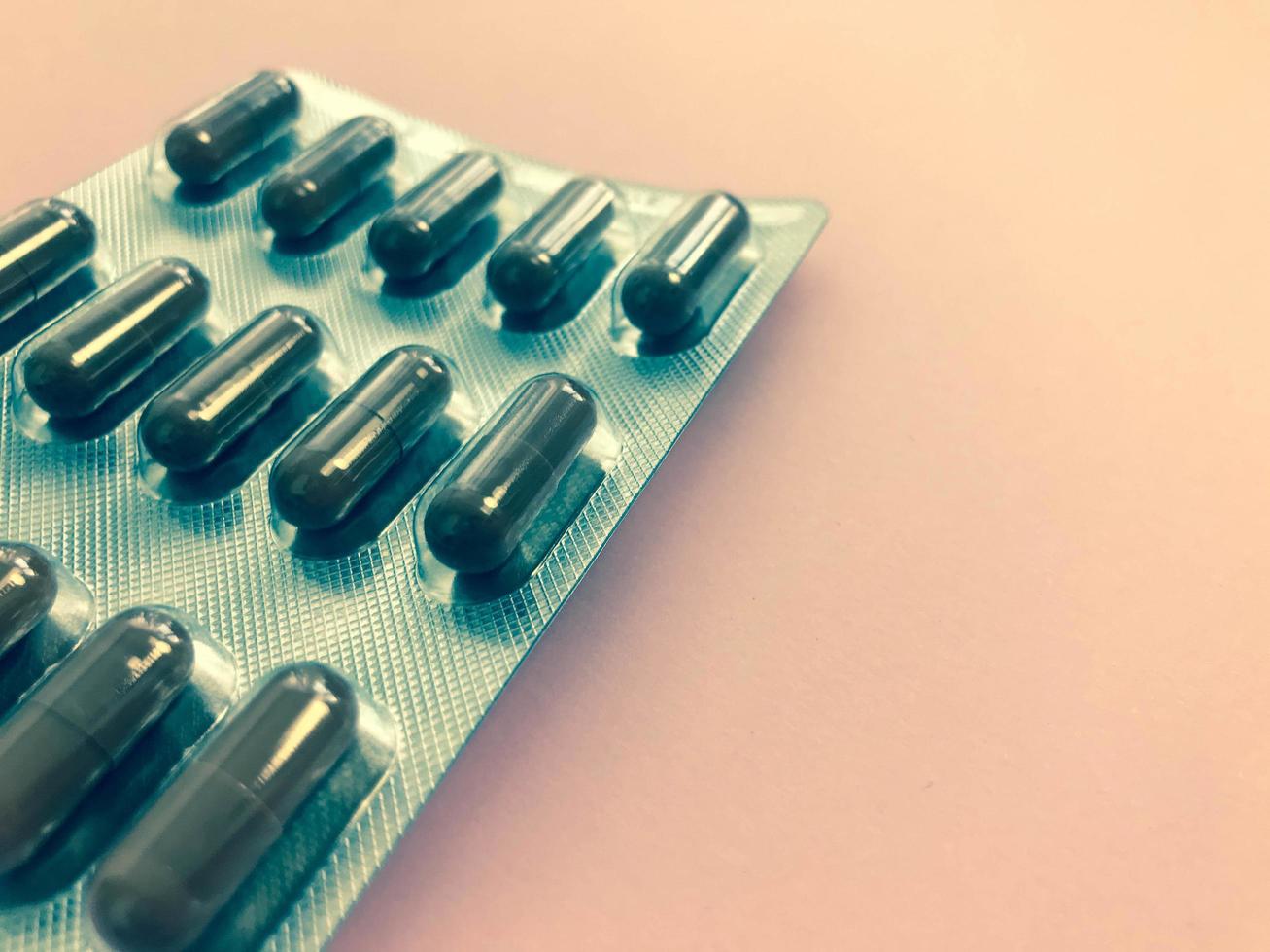 Medical pharmaceutical brown medications for the treatment of diseases and the killing of microbes and viruses tablets and vitamins blisters blisters from coronavirus covid-19 on a pink background photo