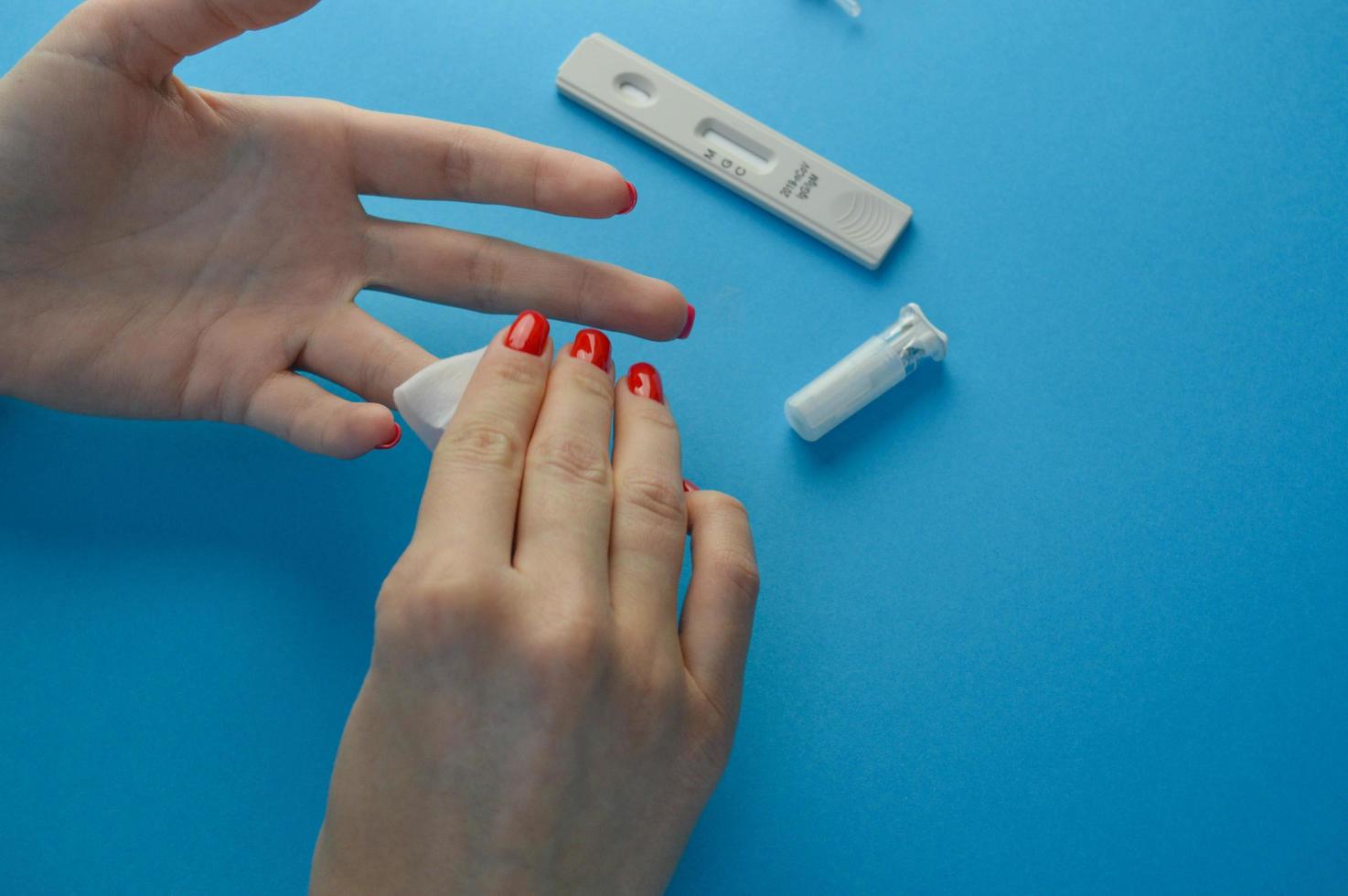 Hands of a nurse with individual protection equipment and patient, in the process of blood collection to make a rapid test for covid-19 coronavirus, in a hospital ward with sanitary elements photo