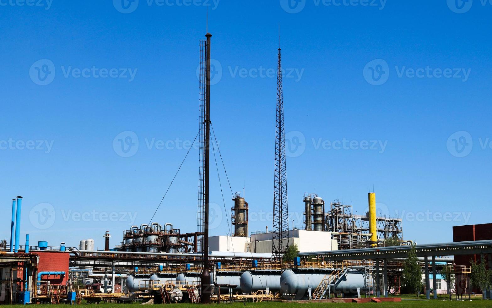 A large concrete technological industrial installation at a chemical petrochemical refinery with capacitive pipes by pumps compressors heat exchangers by pipelines and buildings photo