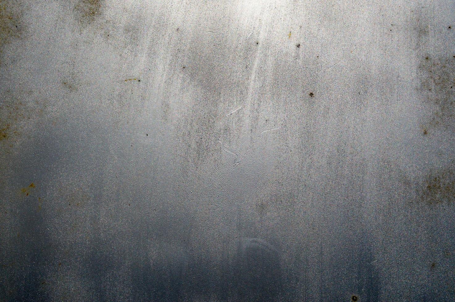 The texture of a silvery light shiny scratched aluminum globule of iron with rusty spots interspersed. The background photo