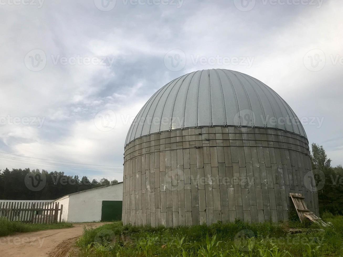 A large round concrete and metal barn for storing grain and corn photo