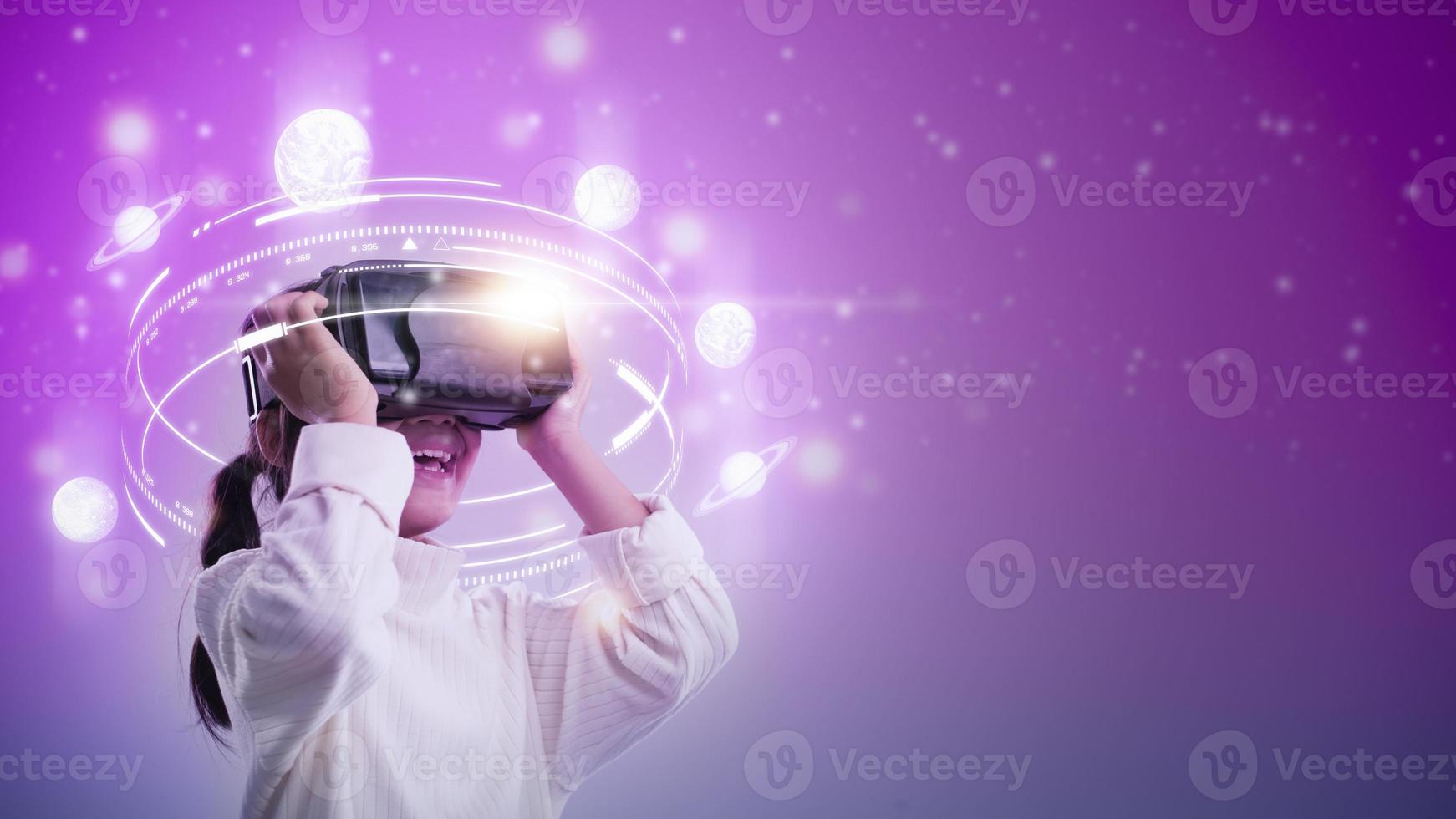 Child girl wearing virtual reality headset and looking at digital space system with planets or Universes. Space exploration with augmented reality glasses. photo