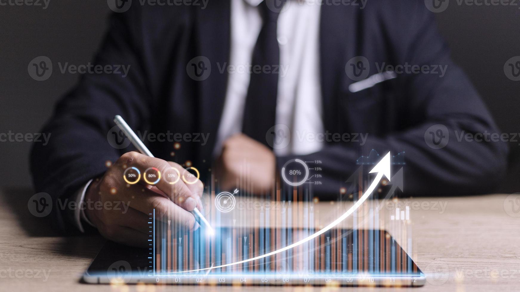 people using tablets And using his finger to touch the screen With a business graph showing up in a virtual screen.New startup ideas and business growth concept. photo