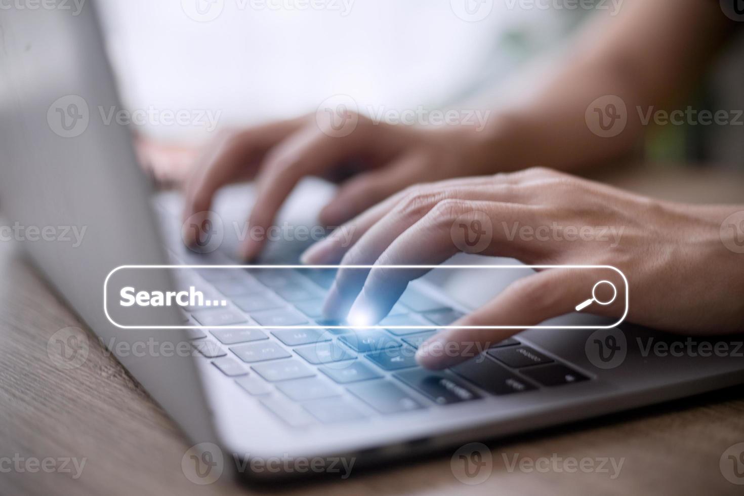 People hand using laptop or computor searching for information in internet online society web with search box icon and copyspace. photo