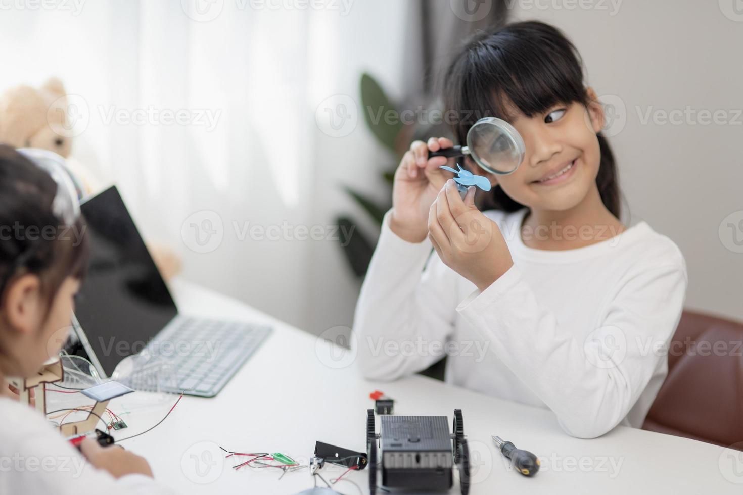 Two Asian students learn coding robot cars and electronic board cables in STEM, STEAM, mathematics engineering science technology computer code in robotics for kids concepts. photo