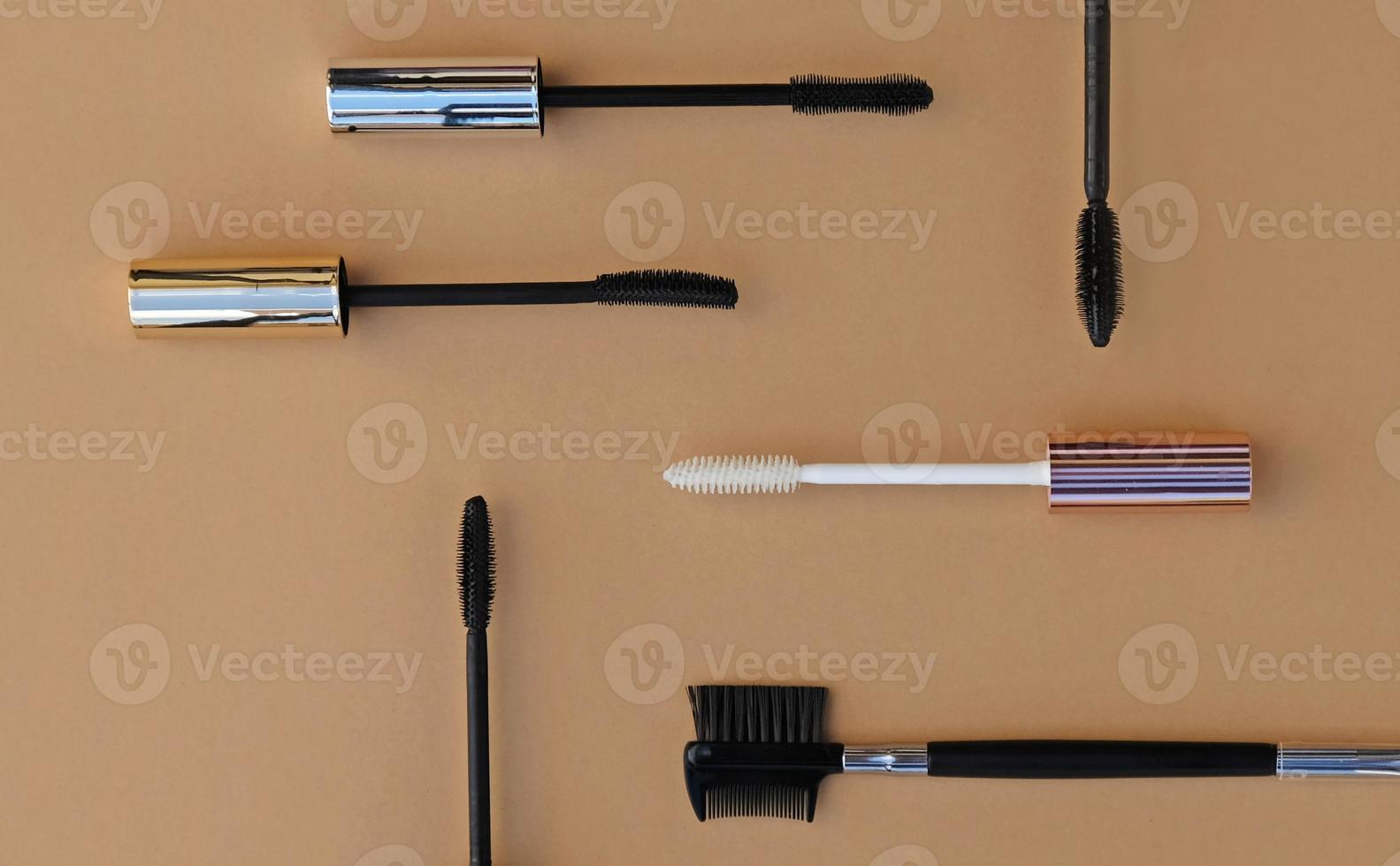 Flat lay makeup set for expressive eyelashes. Different shapes of mascara brushes, eyelash primer, eyebrow and eyelash brush. The concept of accessories, tools and cosmetics for the eyelashes. photo