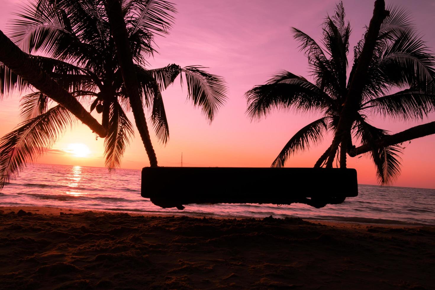 columpio de madera con palmera en la playa tropical puesta de sol sobre el mar para viajar en vacaciones relax tim foto