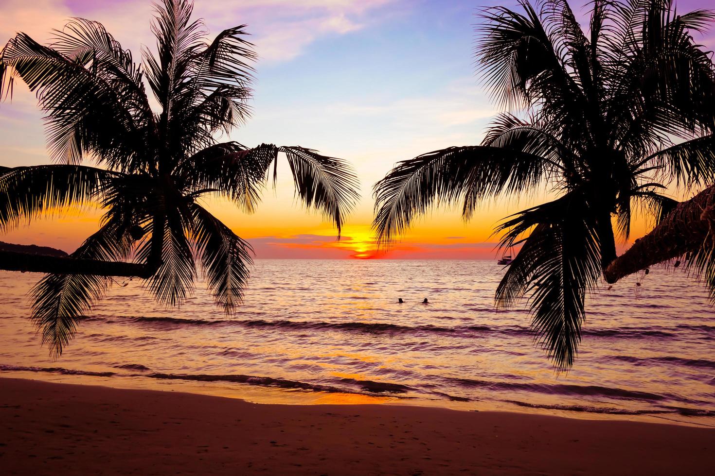 silueta de palmeras hermosa puesta de sol en el fondo de la playa del mar tropical para viajar en tiempo de relajación de vacaciones, foto
