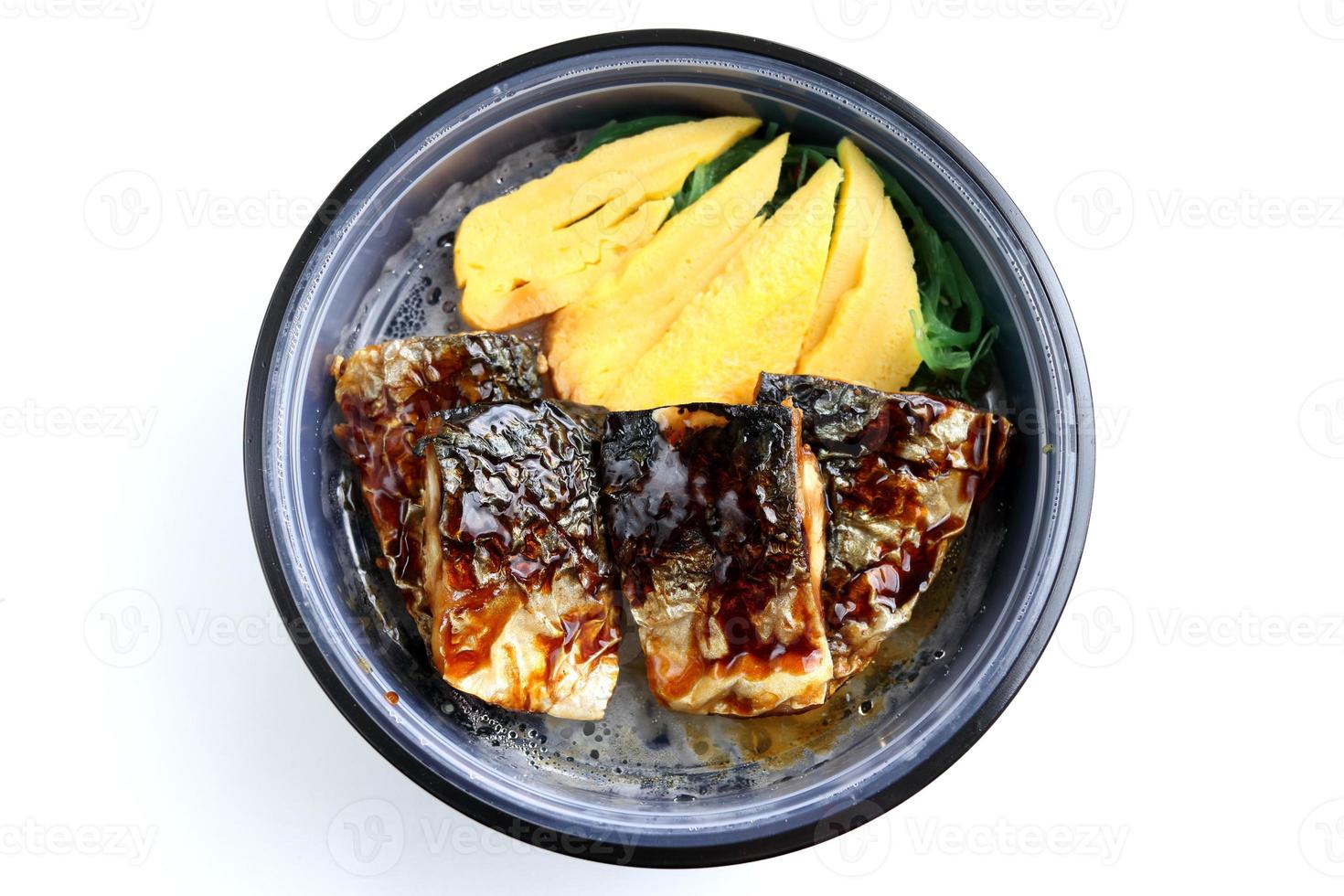 Mackerel fish grilled with Janpanese sweet egg are on rice in black bowl and teriyaki sauce on top and white background, Thailand. Japanese dish set. photo