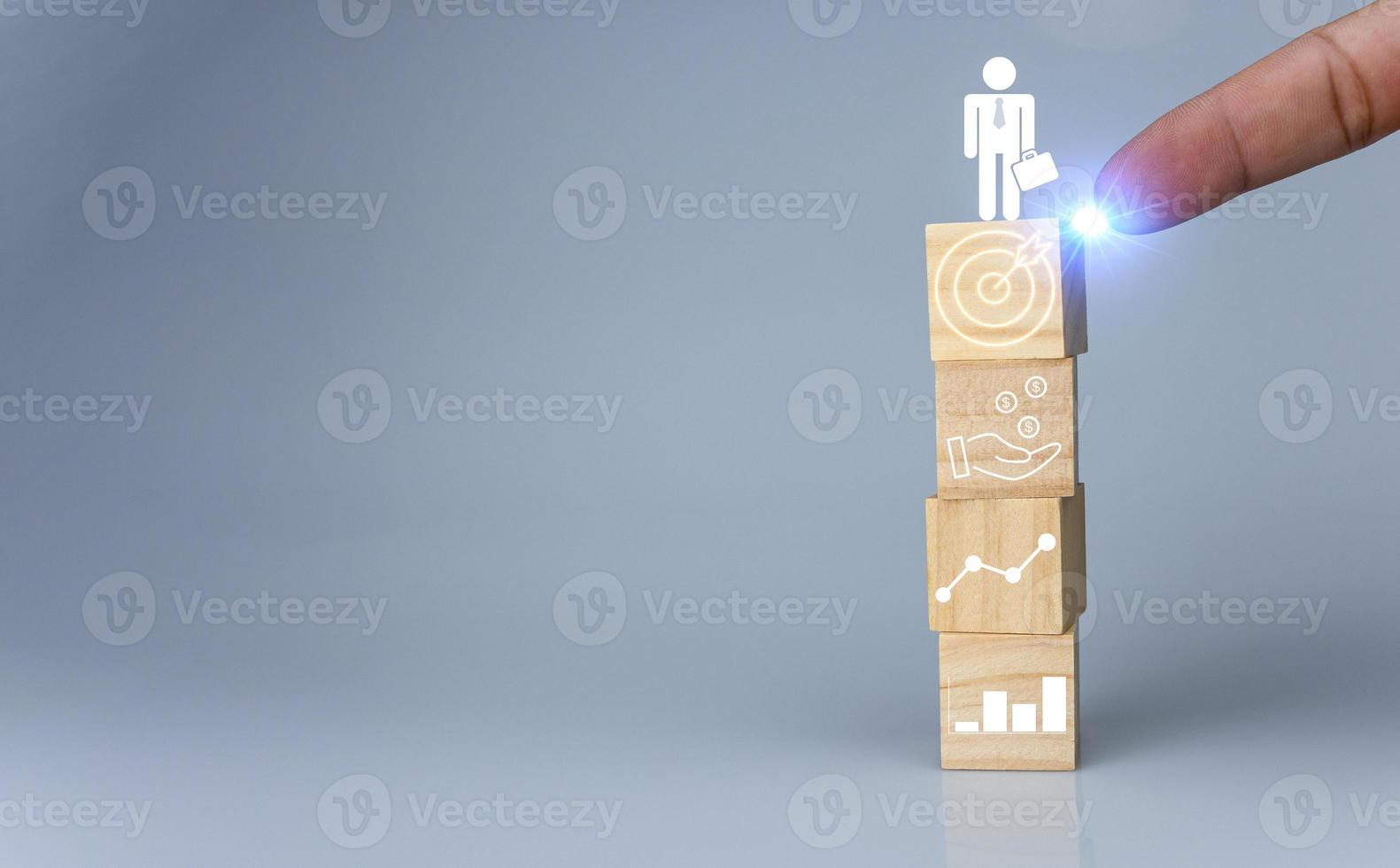 Hand pointing at one wood cube block with target icon . Concept of business strategy and goal action plan. photo