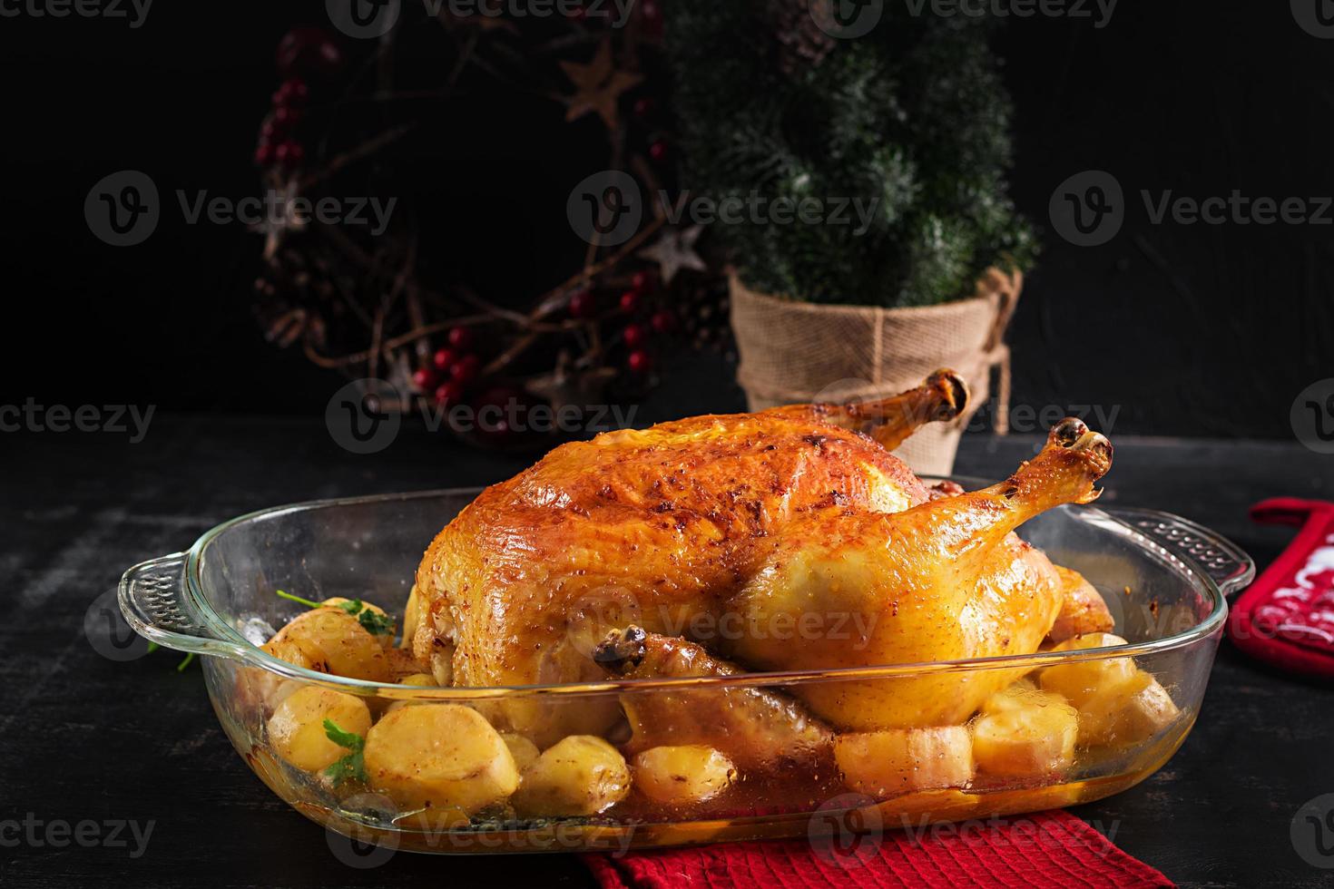 Baked turkey or chicken. The Christmas table is served with a turkey, decorated with bright tinsel. Fried chicken, table. Christmas dinner. photo
